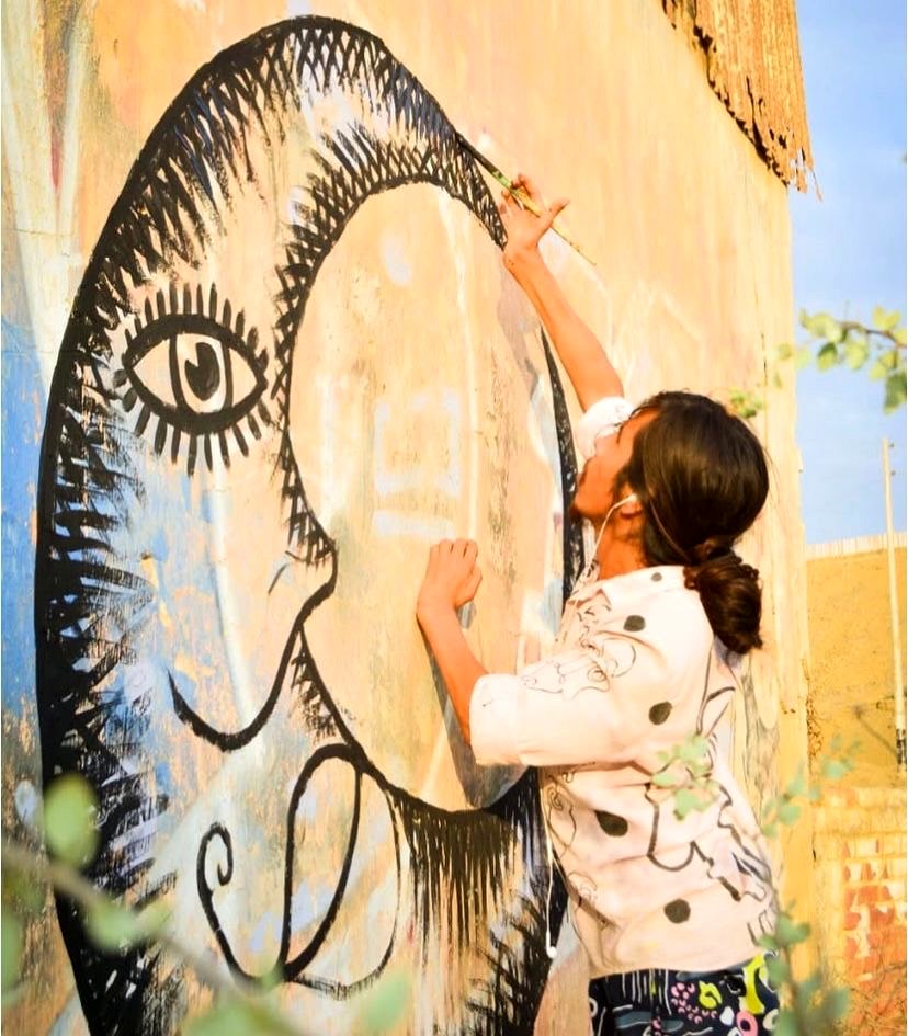 Inti painting a large mural in Lobitos